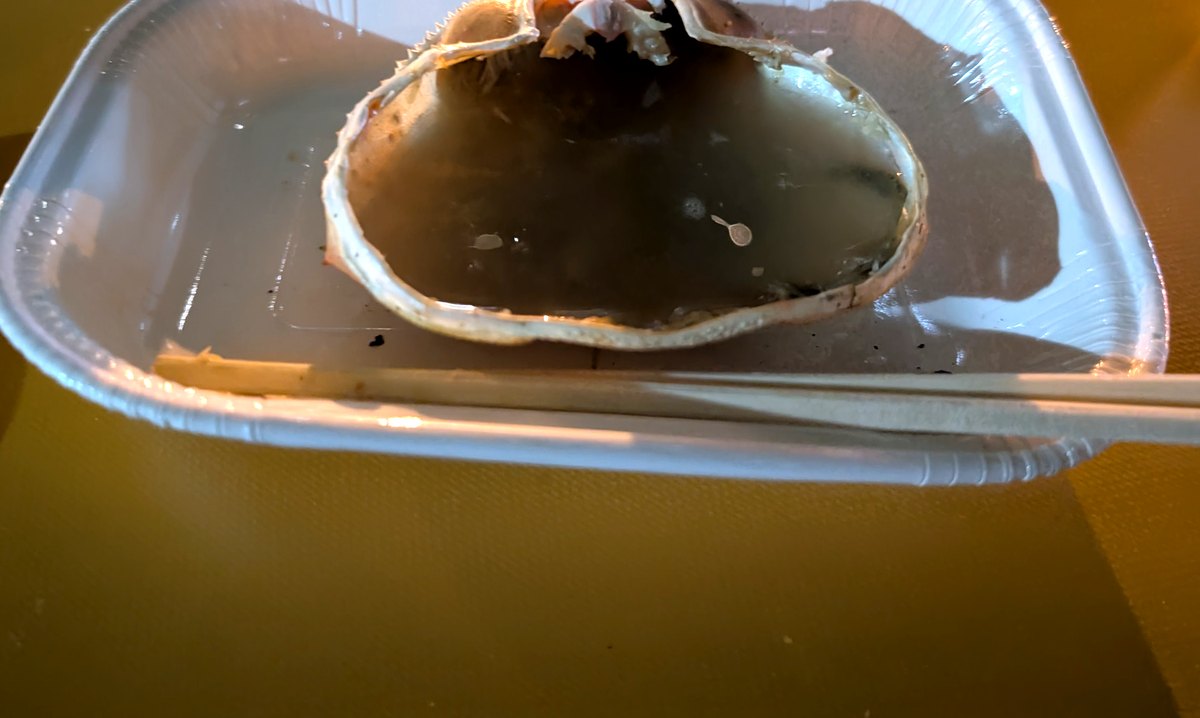 食べ終えた蟹の甲羅に日本酒を注いだ甲羅酒
