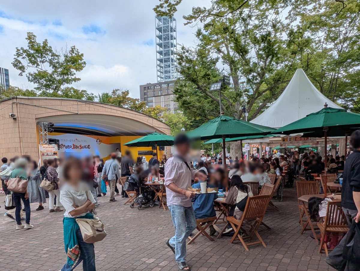 さっぽろオータムフェスト2026 西6丁目 緑のパラソルの下のテーブル席とSAPPORO JAM STAGE