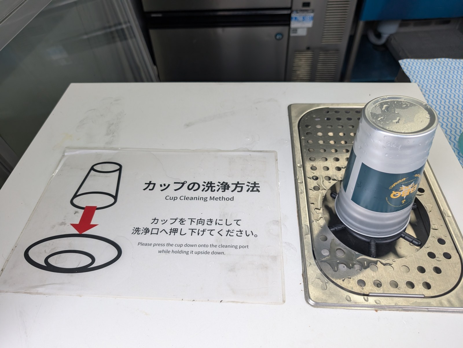 カップの洗浄口。掲示のとおり、カップを下向きにして押し下げると洗浄されます