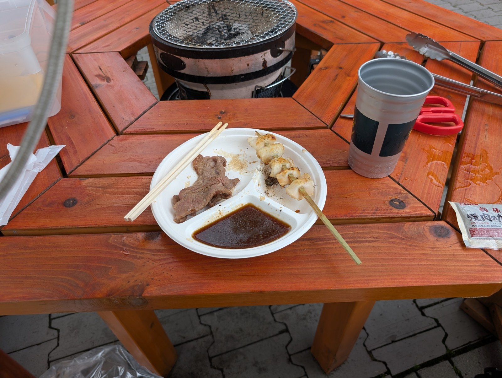 焼き上がったジンギスカンとホタテ串。タレは皿の仕切りに