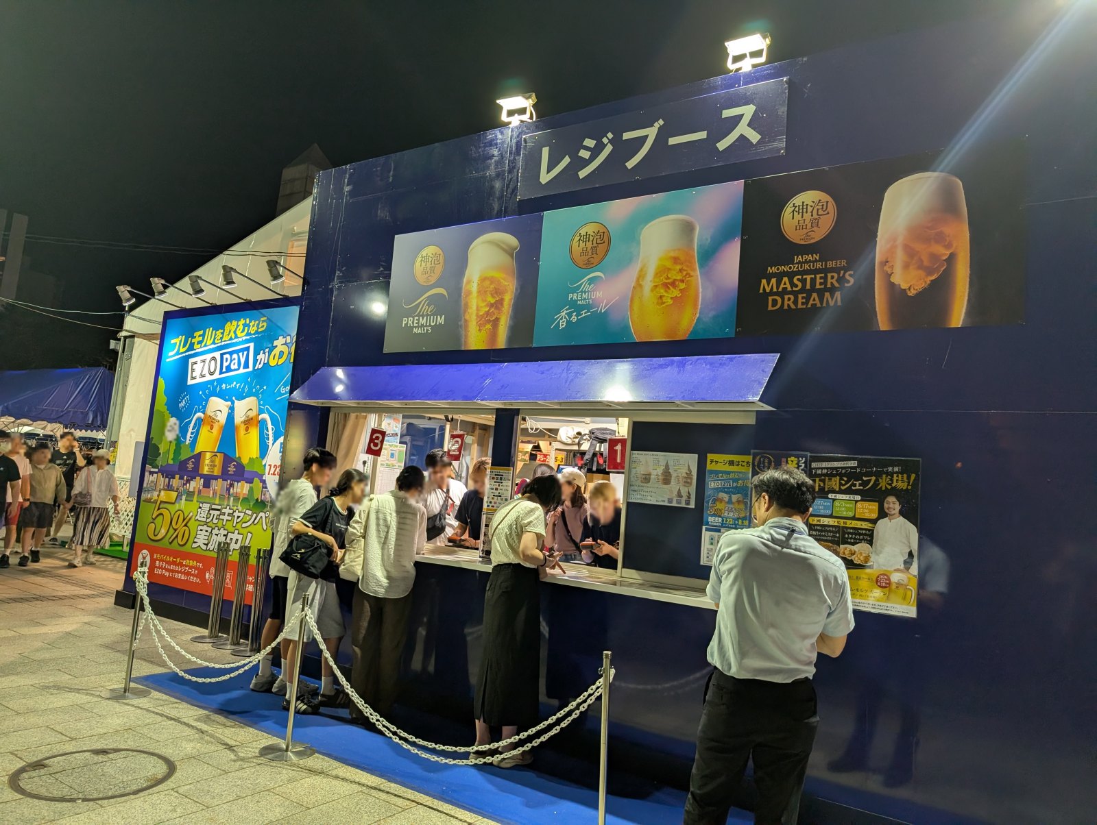 夜の大通ビアガーデン5丁目サントリー会場のレジブースとEZO Pay還元キャンペーンのポスター