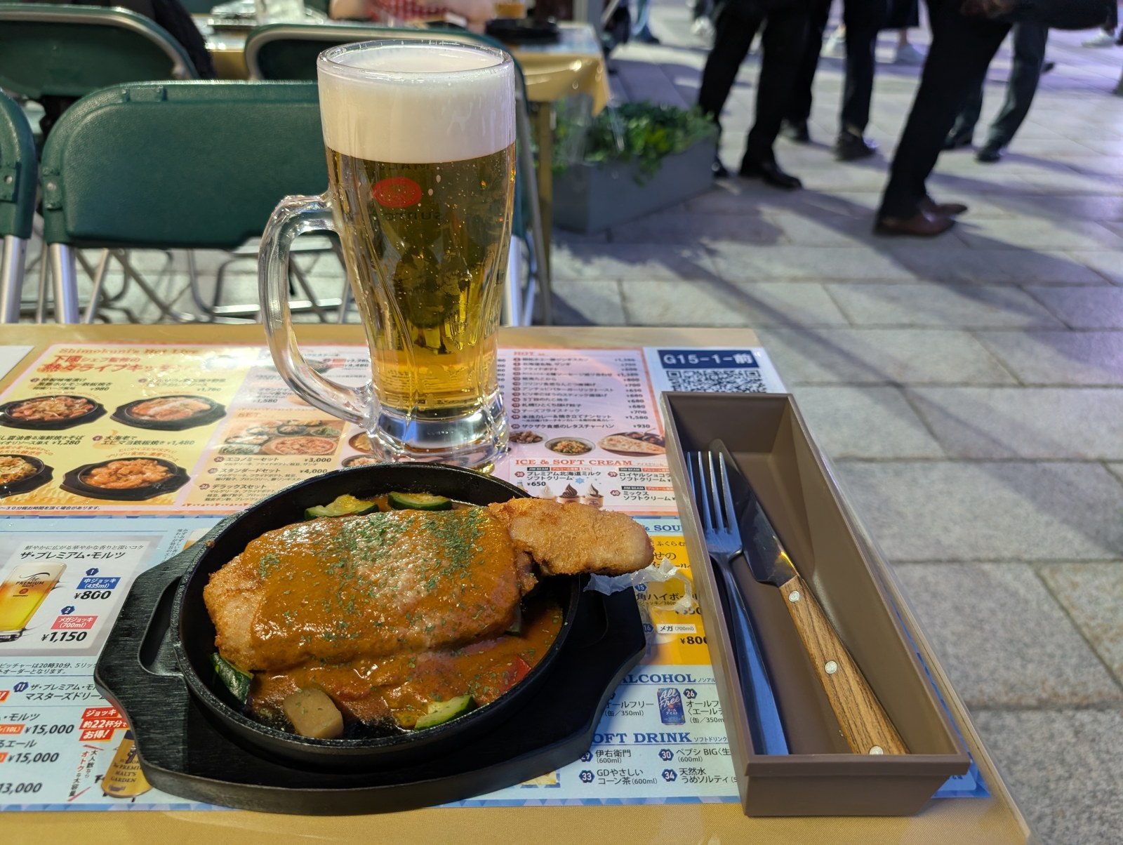 鉄板スキレットに盛られたとんかつのビスクカレーソースがけと泡たっぷりのプレモル中ジョッキ