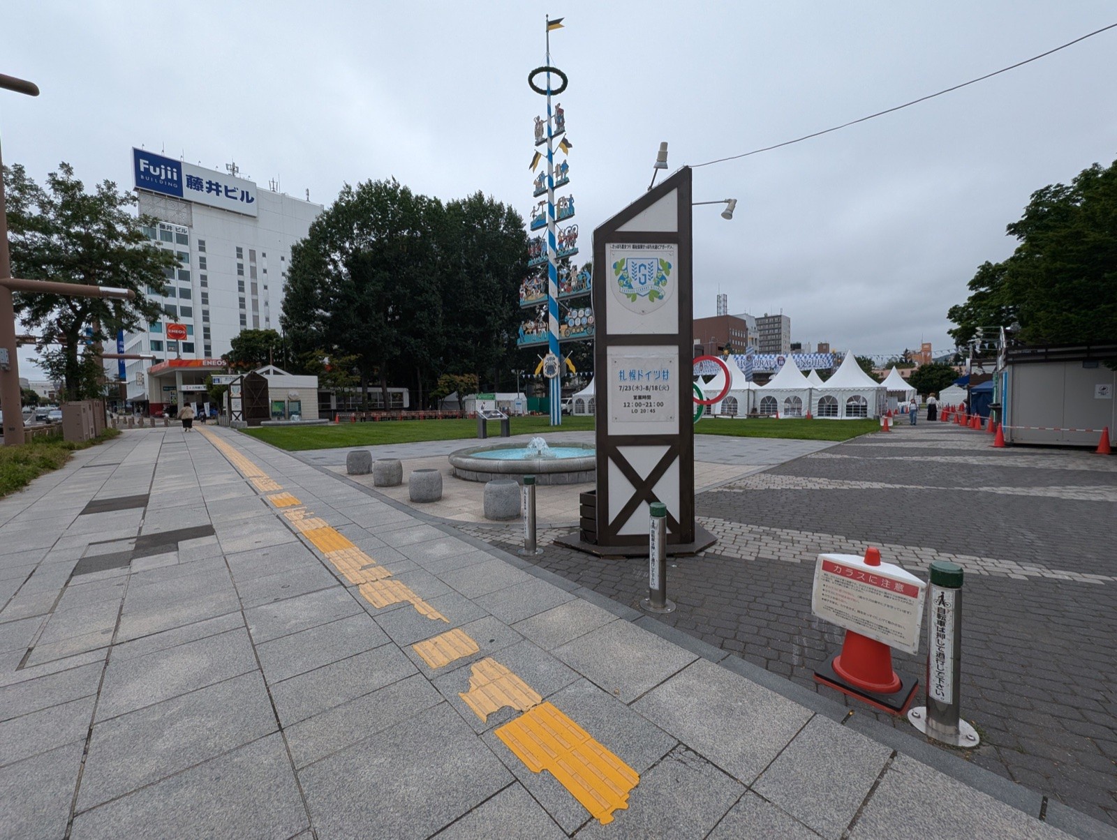 設営中の札幌ドイツ村会場入口。木製の看板塔とマイバウム、奥に白いテント群