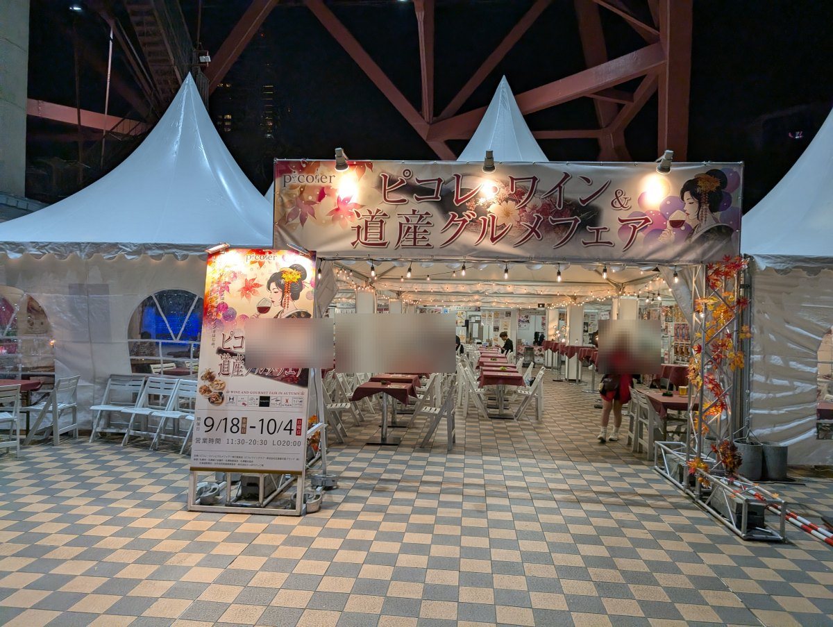 テレビ塔の真下に立つ入口ゲート。看板に会期「9/18-10/4」と営業時間「11:30-20:30 LO20:00」が出ています(2026年9月19日 撮影)