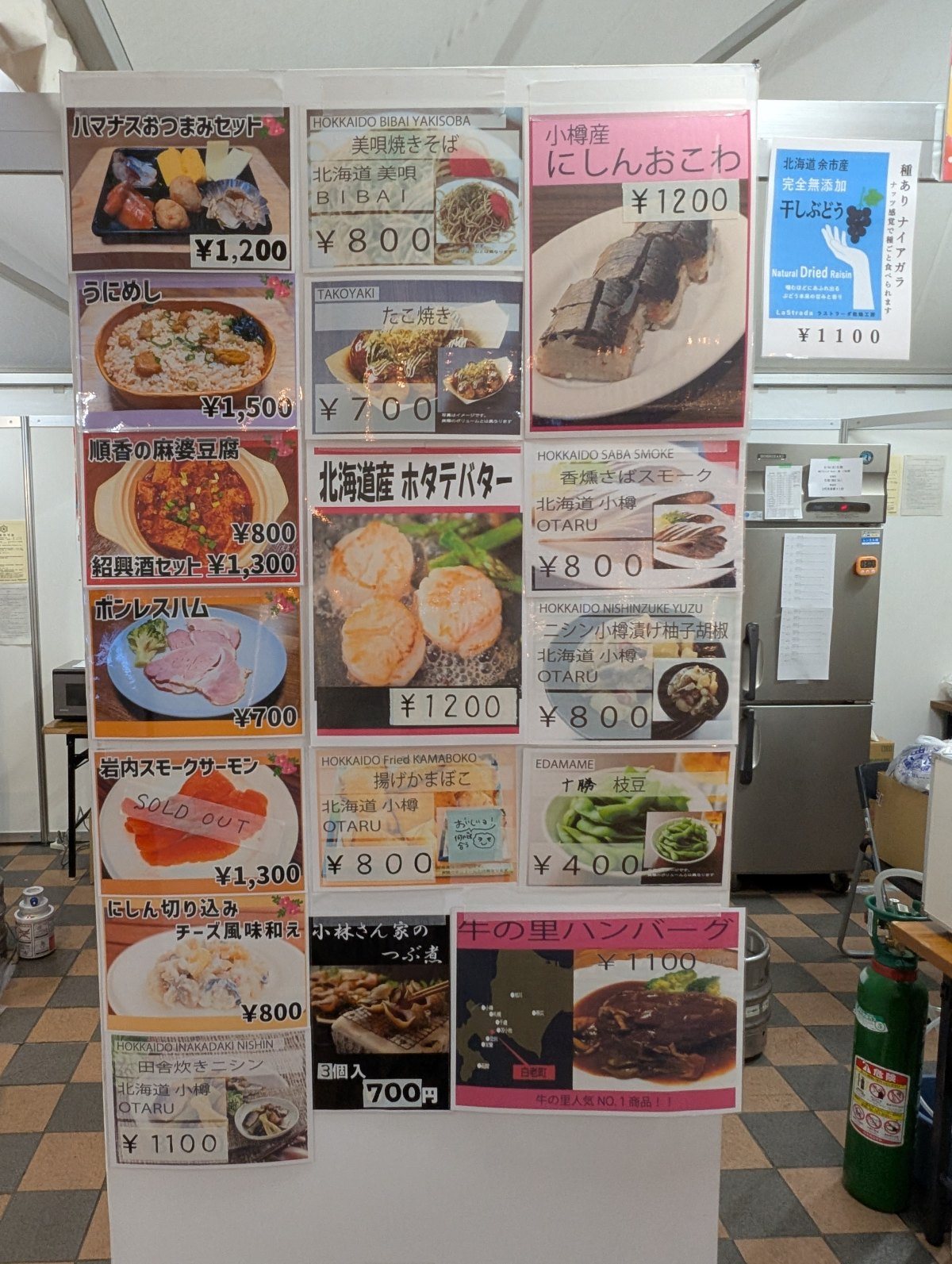 フードの札。小樽の海鮮ものが多く、いちばん安いのは十勝の枝豆400円。岩内スモークサーモンには「SOLD OUT」が貼られていました(2026年9月19日 撮影)