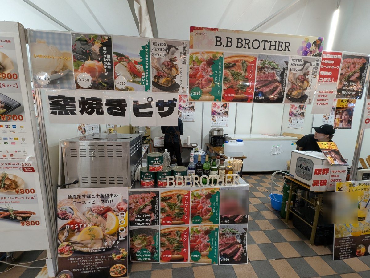 「窯焼きピザ」の文字が目を引きます。手前の立て看板がFOOD/DRINKの一覧(2026年9月19日 撮影)